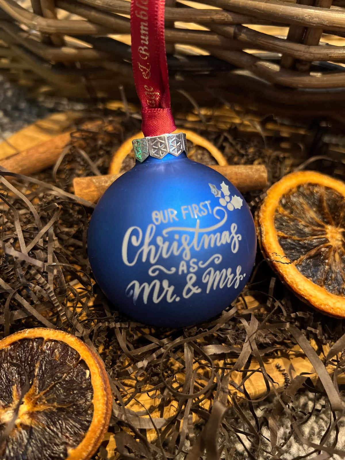 A personalized royal blue Christmas ornament with white script text reading 'OUR FIRST Christmas AS Mr. & Mrs.